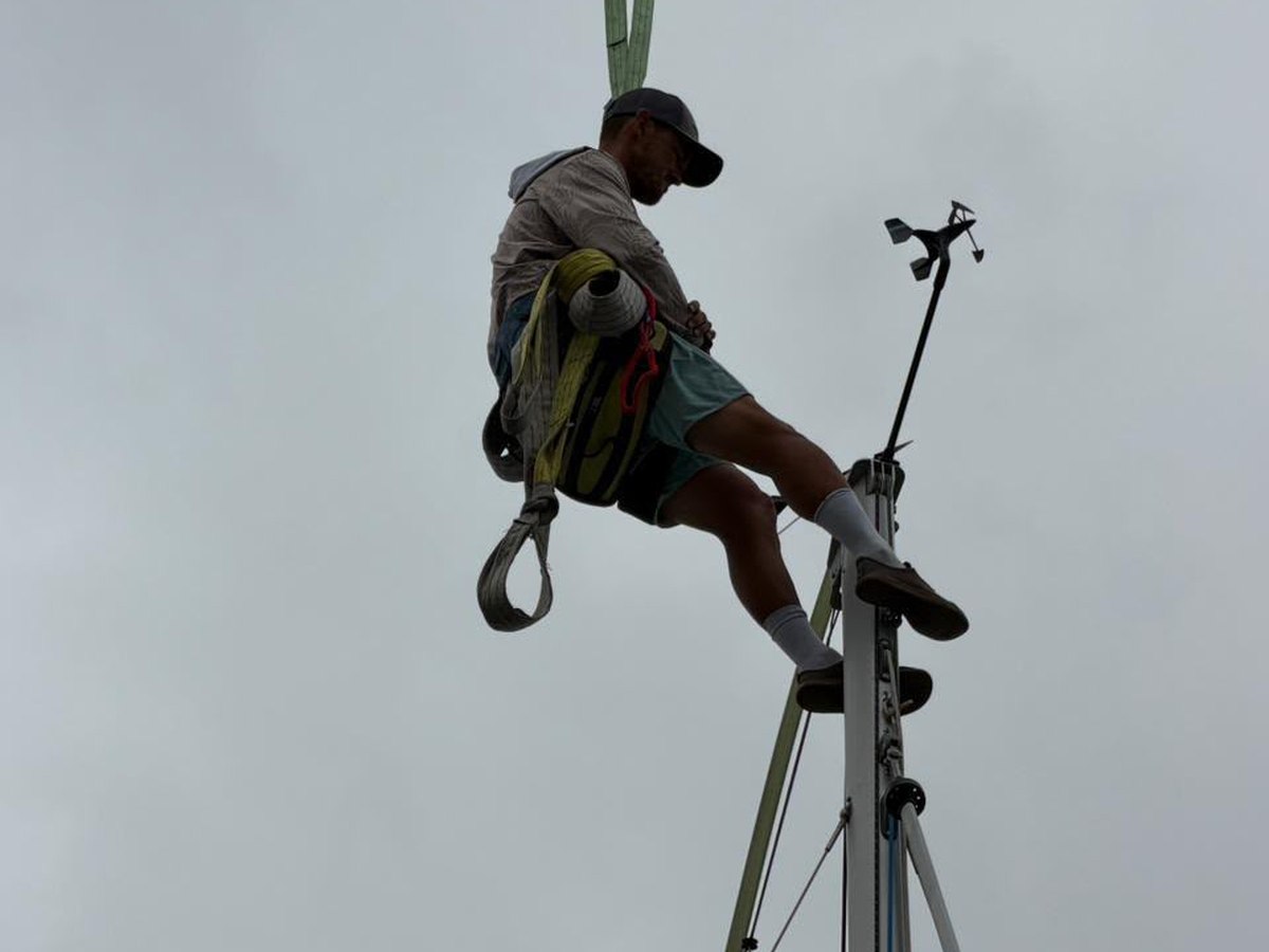 Tan Services technician stepping a mast by crane in Dubai
